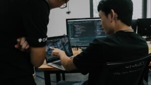 two men working on computers in an office