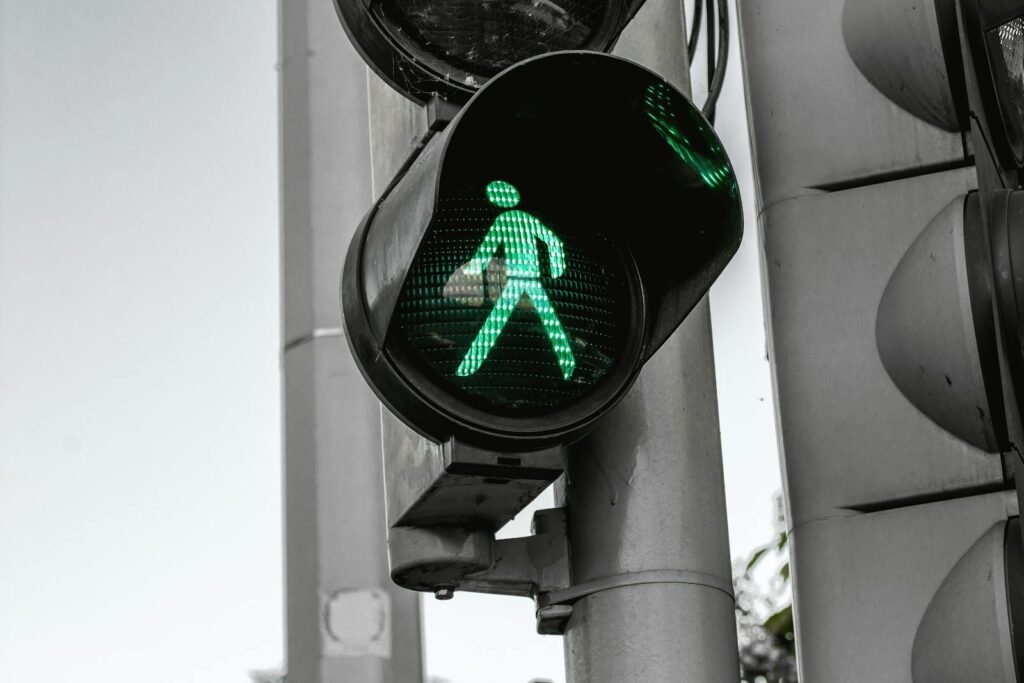 Close-up of a green pedestrian traffic signal indicating walk at an intersection.